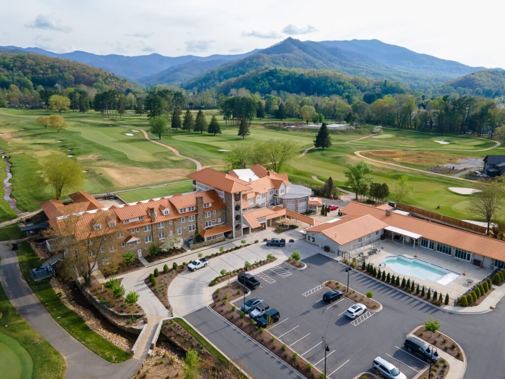 Drone aerial photo of Waynesville Golf Resort in North Carolina, showing clubhouse, pool, and mountain views.